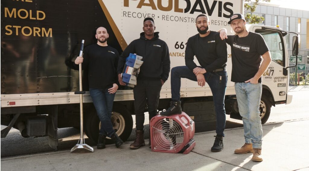 Paul Davis Restoration of Eastern Ohio team standing in front of service truck with restoration equipment, ready for water, fire, mold, and storm damage response.