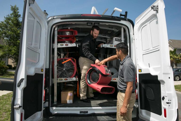 Paul Davis Restoration technicians unloading commercial drying equipment from service van for emergency water damage restoration in Eastern Ohio.